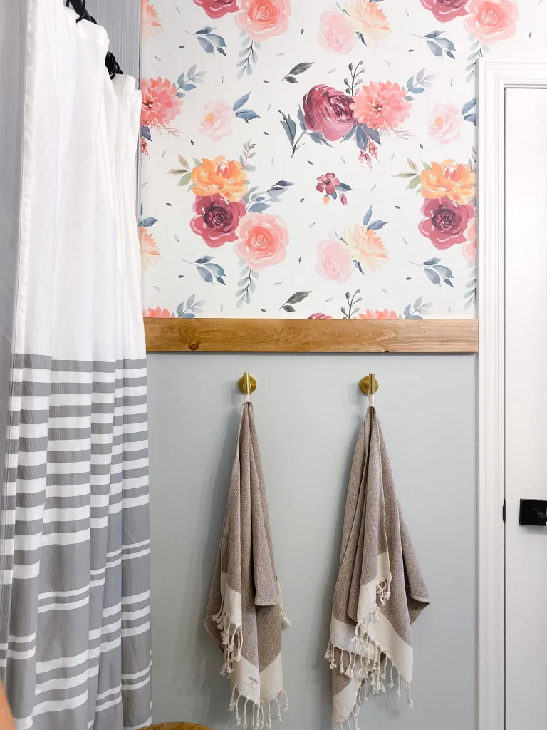 watercolor floral peel and stick wallpaper in a bathroom with hold towel hooks