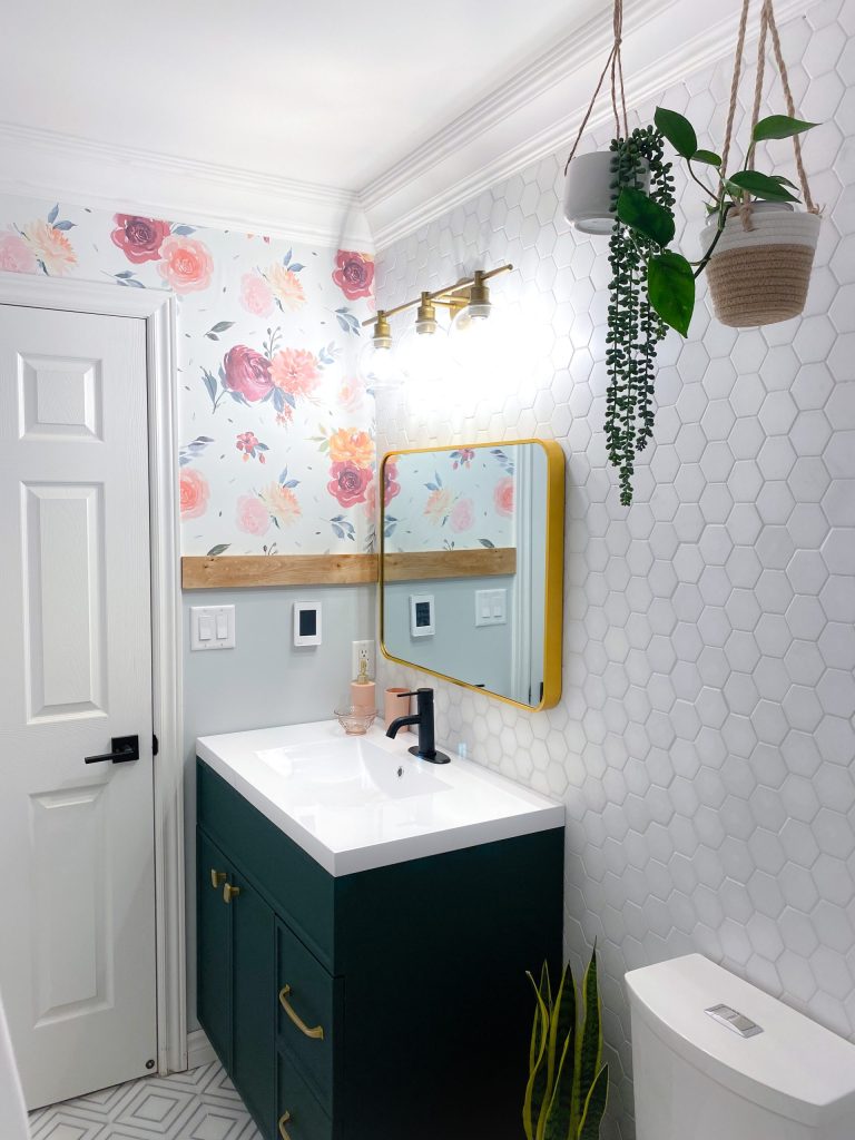 hanging planters in a girls bathroom with a floral wallpaper and hexagon wall tiles