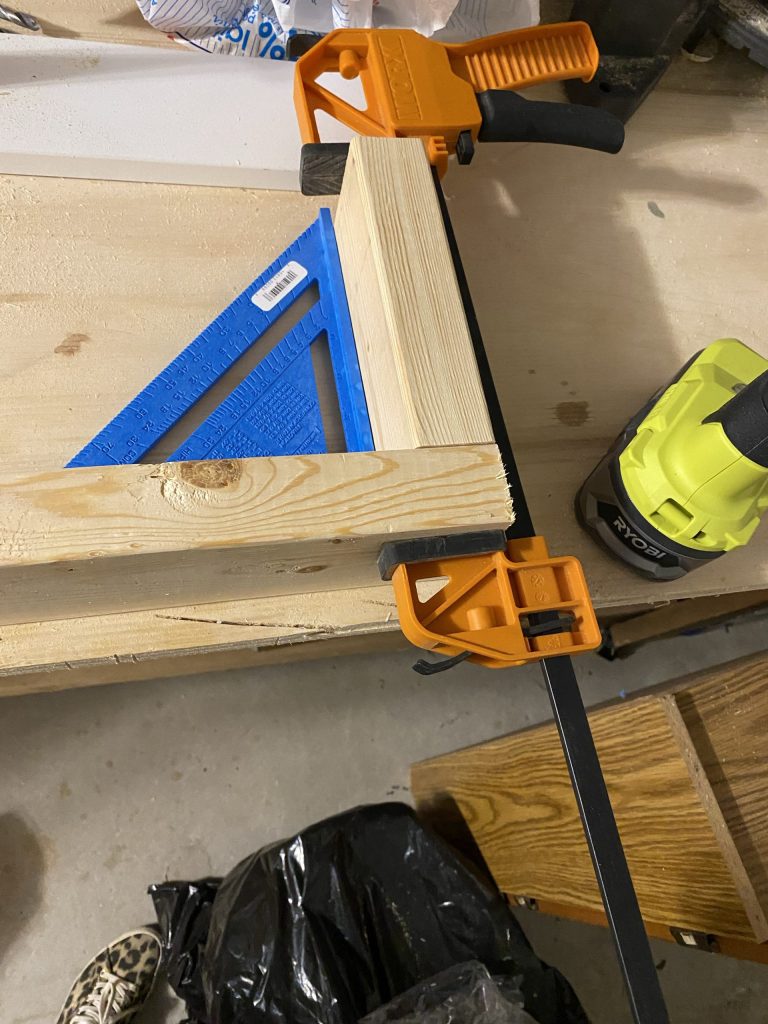 Using a clamp and speed square helps to build the fireplace frame