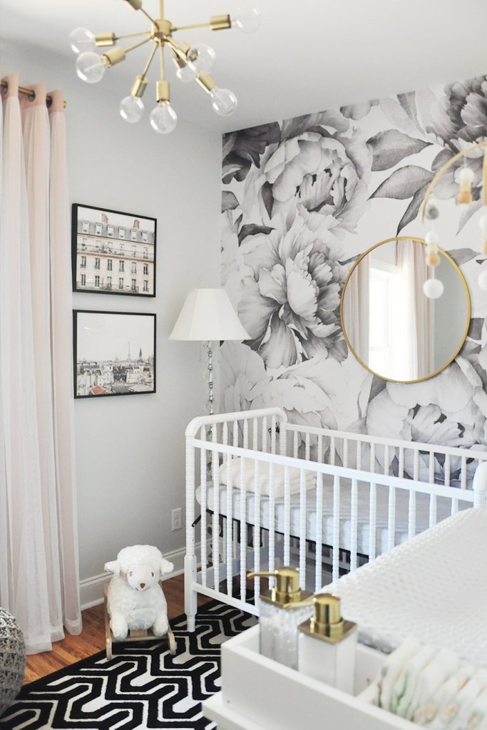 Moody floral nursery for baby girl with black flower wallpaper and gold sputnik lighting