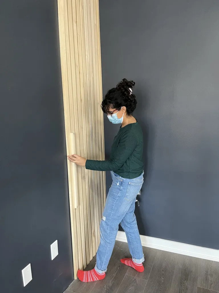 Using a spacer to ensure even distancing of slats on the wall